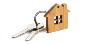 Wooden keychain in the shape of a house with two keys attached - Cripps Realty